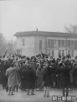 １９４９年１月１日、仮宮殿の宮内府庁舎の屋上にお一人であらわれ、参賀者に手にした帽子を振って応える昭和天皇（後方建物の上）