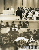 総理府と東京都主催の成人記念式典で、沖縄代表の島袋俊二さんと棚原シゲ子さんの誓いの言葉を聞く皇太子さまと美智子さま。東京・上野の東京文化会館で