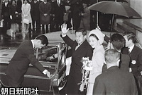 シンガポールから羽田空港に到着し出迎えの人たちに手を振る皇太子さまと美智子さま