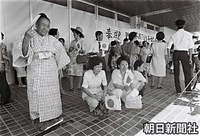１７日午前、那覇空港で日の丸を手に、皇太子さまの到着を待つ女性たち