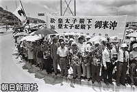 那覇空港から糸満市に続く沿道で、歓迎の横断幕を掲げて車列を待つ人たち