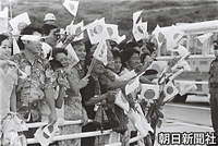 本部町の渡久地新港で、日の丸や海洋博の旗を振って皇太子ご夫妻を見送ろうと集まった人たち