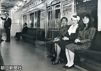 ５月、「こどもの国」開園２０周年の式典に向かうため、営団地下鉄（現東京メトロ）青山一丁目駅から臨時電車に乗って座席に腰掛けた紀宮さま、美智子さま、皇太子さま。中づり広告は取り外されている。電車利用は、