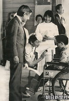 ８月、群馬県吾妻郡草津町の国立ハンセン病療養所「栗生楽泉園」を訪れ、車椅子の患者の目を見ながら話しかける美智子さまと皇太子さま