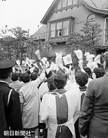 １９５９年４月、お祝いに訪れる近所の人たちに、自宅の窓から手を振って応える