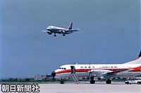 植樹祭出席のため、即位後初めて沖縄を訪れる天皇、皇后両陛下を乗せ、那覇空港に着陸する全日空機。右下は南西航空（現・日本トランスオーシャン航空）のＹＳ－１１型機
