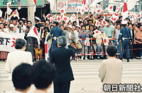ひめゆりの塔で、日の丸の小旗を振って迎えた人たちに手を振って応える。「特等席」におばあたちというのが沖縄らしい