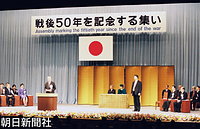 東京・国立劇場で行われた政府の「戦後５０年を記念する集い」であいさつする村山富市首相と後ろで見つめる天皇、皇后両陛下