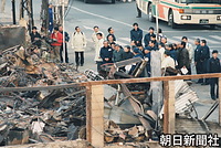 １９９５年１月、阪神淡路大震災で被災した神戸市長田区の菅原市場を視察する天皇、皇后両陛下。皇后さまは焼け跡に皇居の庭で摘み取ったスイセンの花束を供えた