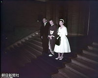 昭和天皇へのあいさつなどを終え、宮内庁を退出する正田美智子さんとご両親。美智子さんはアイボリーのワンピース、白の手袋と靴の清楚な装い