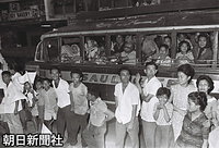 マラカニアン宮殿に向かう車列を文字どおり超満員のバスの中から一目見ようとする人たち