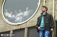 戦没者記念碑がある王宮前広場を見下ろすビルの窓から、儀式を見つめる人たち