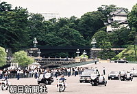 ７月２５日、斂葬（れんそう）の儀が行われる豊島岡墓地に向け皇居・正門を出る皇太后さまのひつぎを載せた轜車（じしゃ）の車列と見送る人たち。後方は伏見櫓