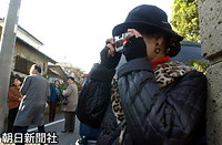 小和田邸を訪れ、レンズ付きフィルムのカメラを取り出して記念撮影を行う女性もいた