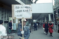 大阪・難波で、京都競馬場開催の中止を知らせる看板を持つ警備員