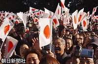 新年一般参賀で、皇居・東庭から宮殿に向かって日の丸の小旗を打ち振る人たち