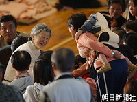 小千谷市総合体育館で、赤ちゃんをおんぶした女性に握手をして笑顔で話しかけられる皇后さま