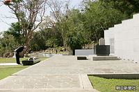 日本政府が建立した中部太平洋戦没者の碑に、白菊の花束を供花したあと、深々と頭を下げられる天皇、皇后両陛下。右は遺骨箱をかたどった石碑