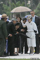 アメリカ慰霊公園にある北マリアナ自治政府が建てた現地島民のための「マリアナ記念碑」に向かう途中、突然降り始めた雨（スコール）のなか、天皇陛下に傘を差し出される皇后さま