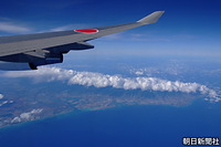 帰国する政府専用機から見えたオアフ島。雲の下の海岸線が右の海に突き出たあたりがダイヤモンドヘッド、左へワイキキ、ホノルル国際空港（現・ダニエル・Ｋ・イノウエ国際空港）、真珠湾（パールハーバー）