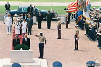 国立太平洋記念墓地で、供花し黙礼される天皇陛下。右は２００９年にも両陛下を案内したジーン・カスタグネッティ同墓地所長。後ろは皇后さまと首席随員の宮沢喜一元首相。その右はジョン・ワイヘイ・ハワイ州知事、
