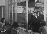 神戸市灘区で、戦災復興用に皇室から下賜された木曽御料林産のヒノキを使用して建てられた兵庫県営烏帽子町庶民住宅を訪問し、住民に笑顔で声をかけられる昭和天皇