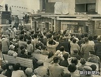 大阪市内のデパート屋上でテレビ（右上）の実況中継に見入る人たち