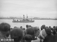信濃川河口にある新潟港を視察する昭和天皇を乗せたお召し艇の鉄拐丸と、歓迎に集まった人たち。新潟港は、ほとんど空襲の被害を受けていなかった