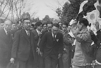 ２３日、高知市の敷島紡績高知工場（現・シキボウ、同工場はすでに閉鎖）で、日の丸を振る従業員の奉迎を受けられる昭和天皇。左は田島道治宮内庁長官