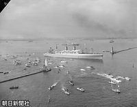 １９５３年３月、エリザベス英女王の戴冠式に向かう皇太子さまを乗せ横浜港を出港しハワイに向かうプレジデント・ウィルソン号。見送りの小型船が白い航跡をひくなか、外防波堤を通過している