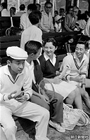 １９５８年８月、長野県軽井沢町の軽井沢会テニスコートの観覧席で、「軽井沢国際テニストーナメント」の出場者と談笑する正田美智子さん。左は皇太子さま。お２人は前年夏に初めてこのコートで出会い、ダブルスで対